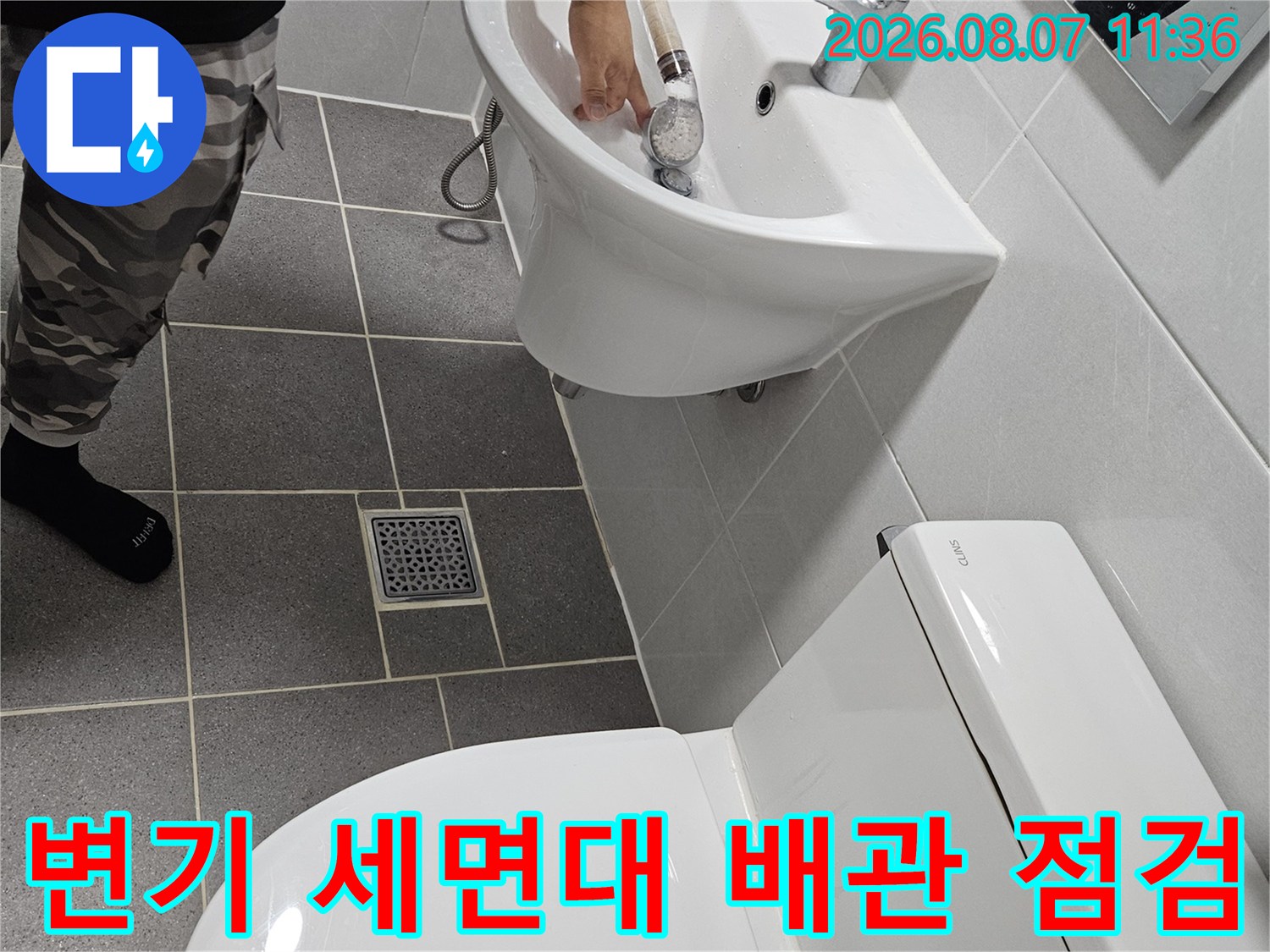 화장실 변기와 세면대의 하부 배관 연결 부위를 상세하게 촬영한 사진입니다.