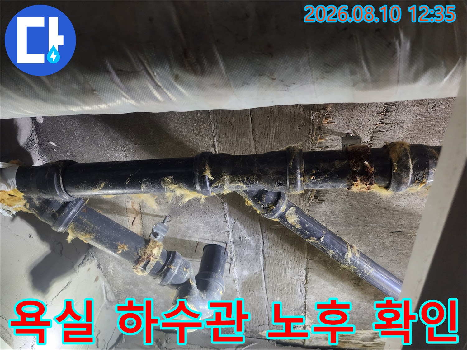 젖어있는 보온재와 테이핑이 풀린-하수 배관의 연결 부위 상세 사진입니다.