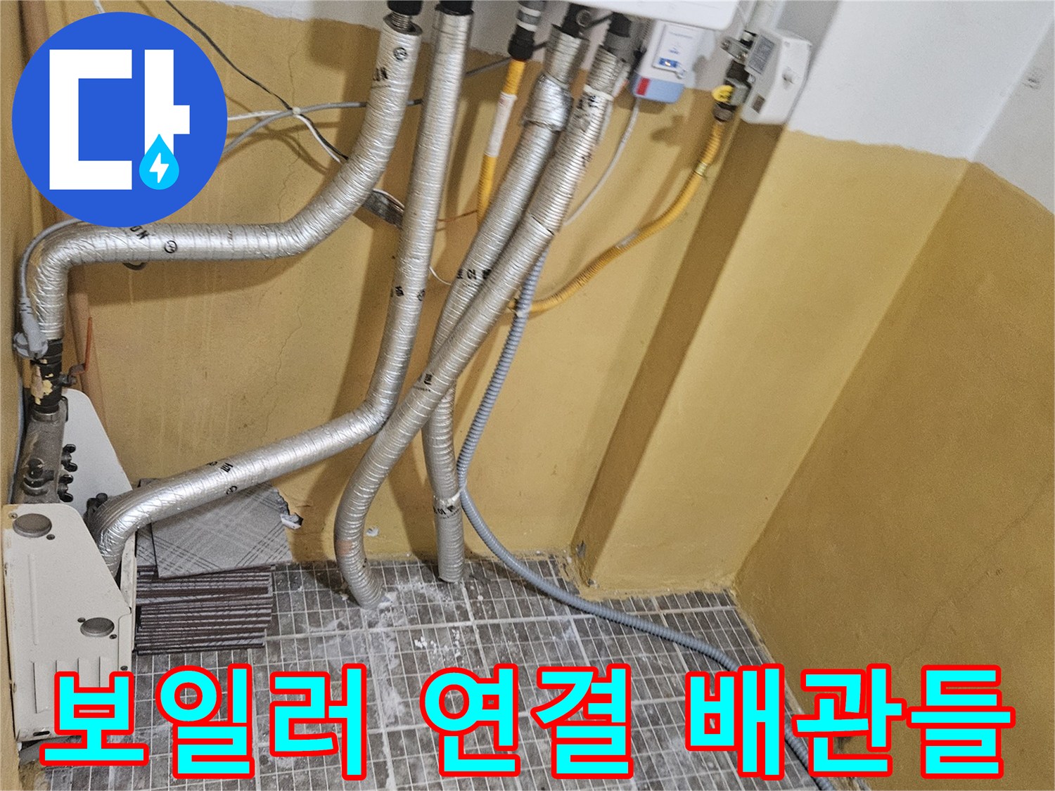 보일러 하부에서 뻗어 나온 은색 보온재 마감 배관