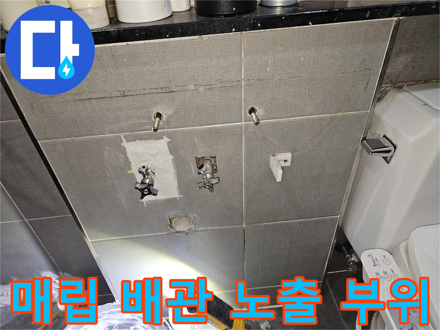 화장실 벽면 타일 제거 후-노출된 수도 배관과 부속 연결부 모습