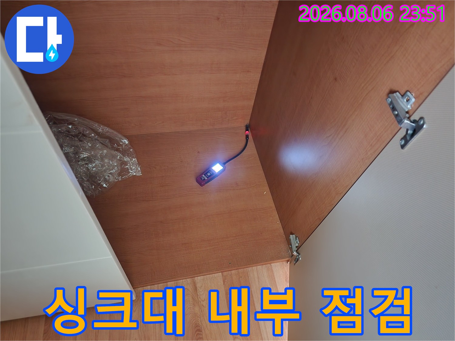 싱크대-하부장-안쪽-배관-주변을-조명으로-밝혀서-보는-모습