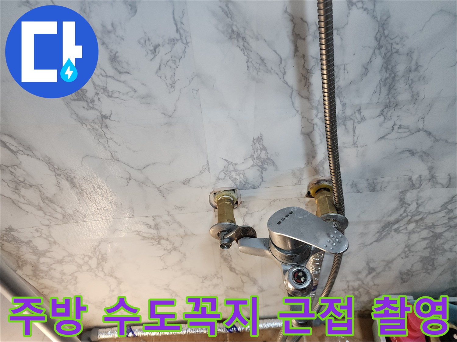 주방 싱크대 벽면 배관과 금속제 수전 연결 모습