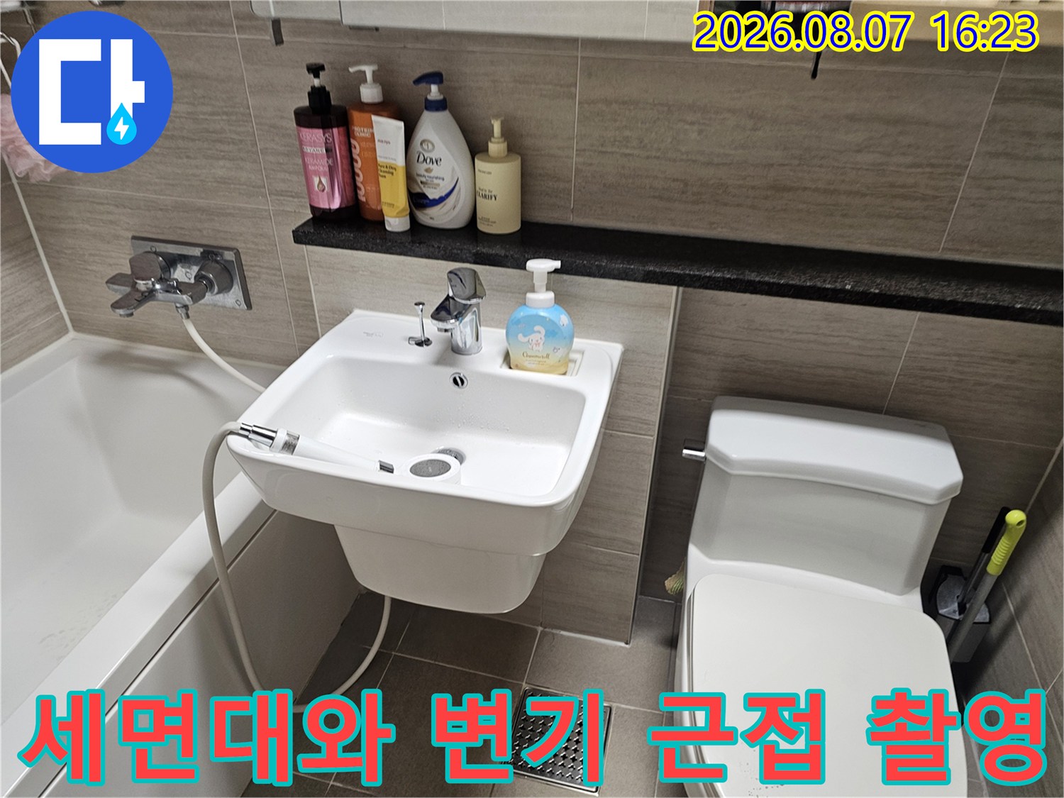 아파트 욕실 내부에 설치된 세면대와 변기의 모습입니다.