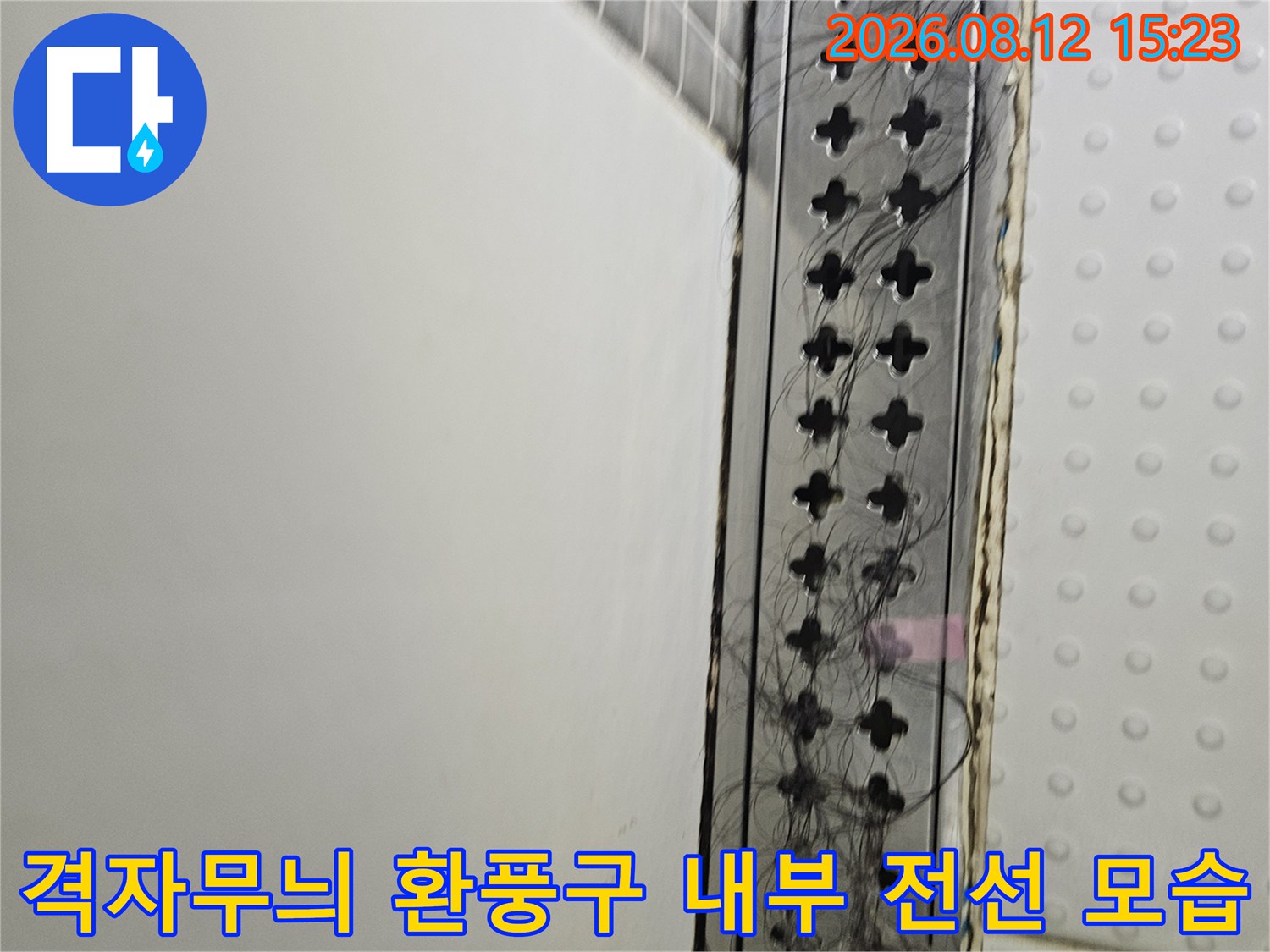 아파트 천장의-격자 모양 환기구 틈새로 노출된 검은색 배선들