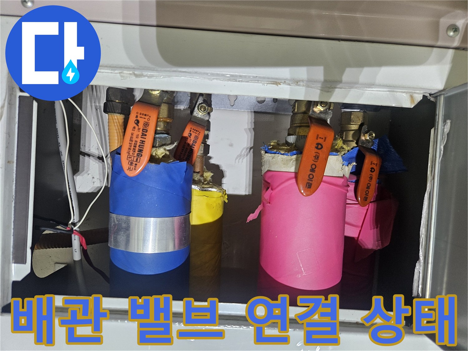 주황색 손잡이 밸브와 배관 연결부 사진