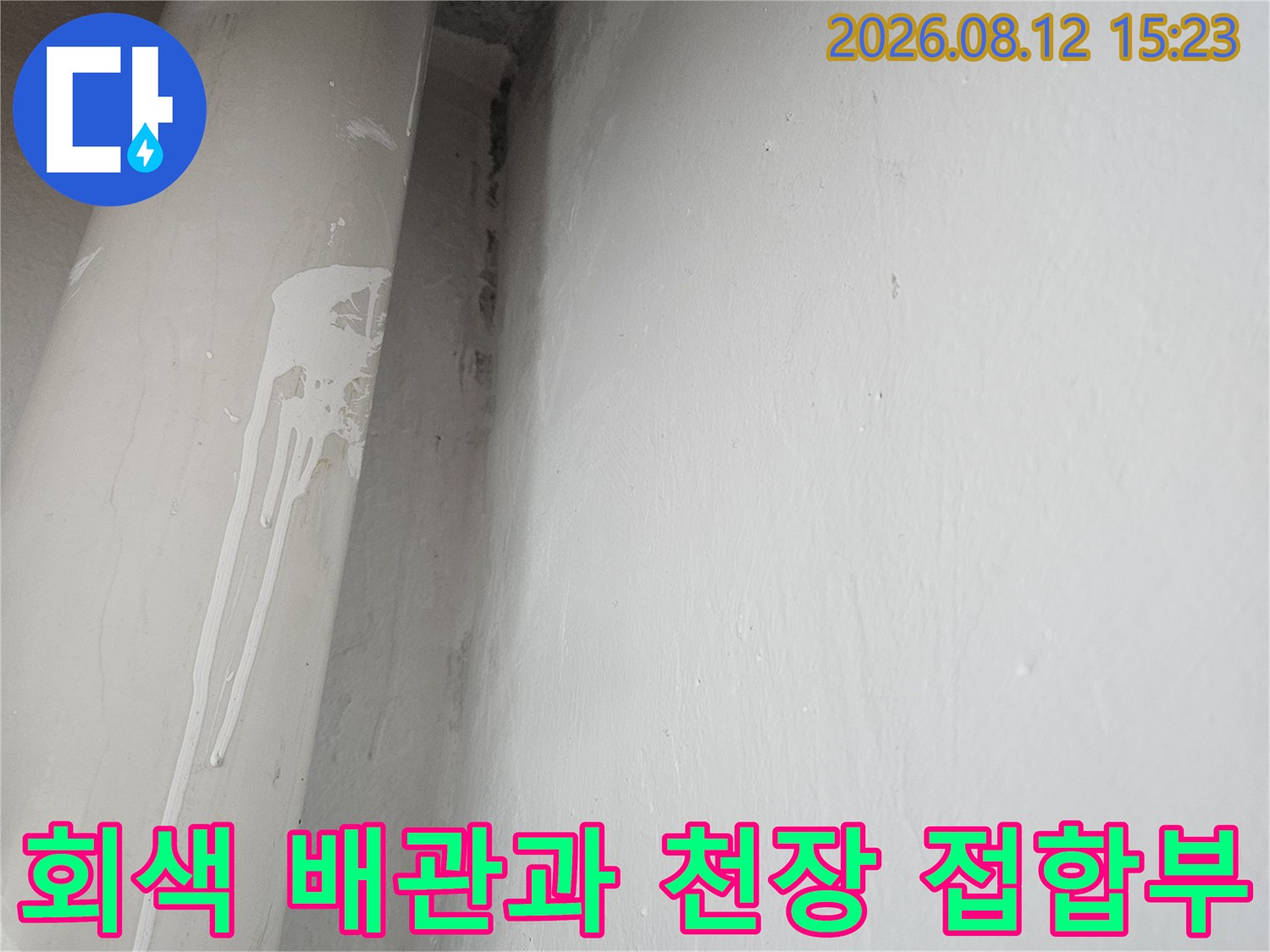천장 모서리 부분에 설치된 두꺼운 회색 배관의 외형 사진