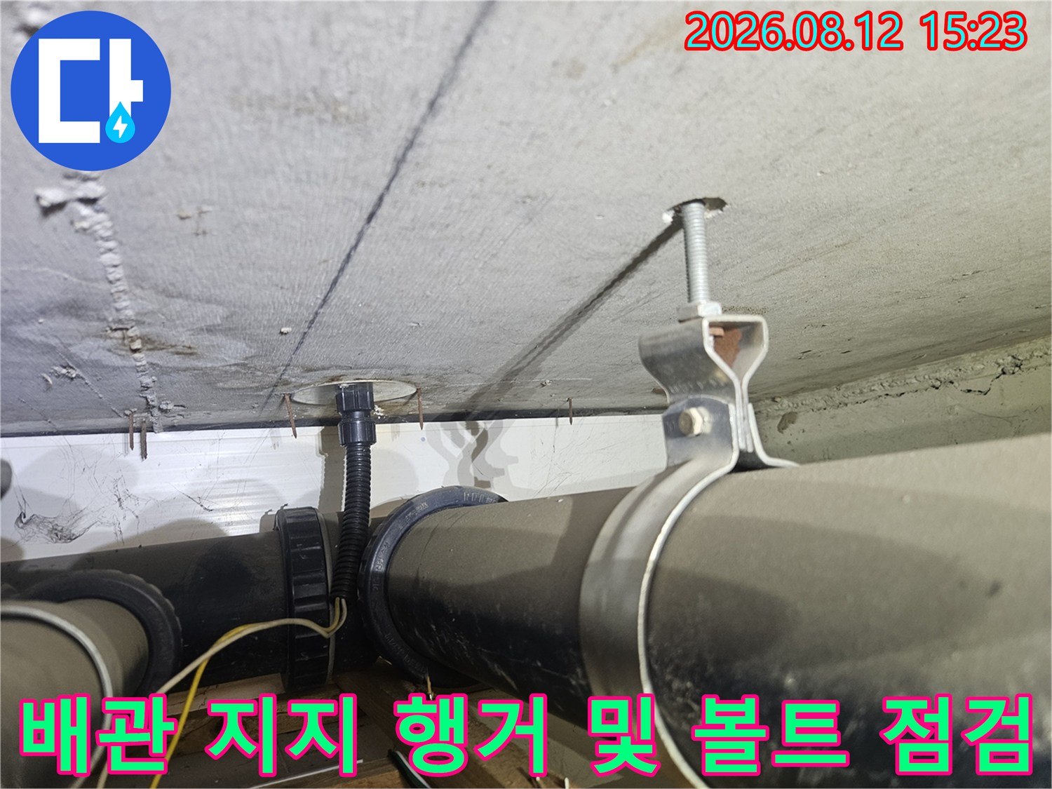 천장 콘크리트 면에 고정된 전산볼트와 배관을 받치고 있는 금속 행거