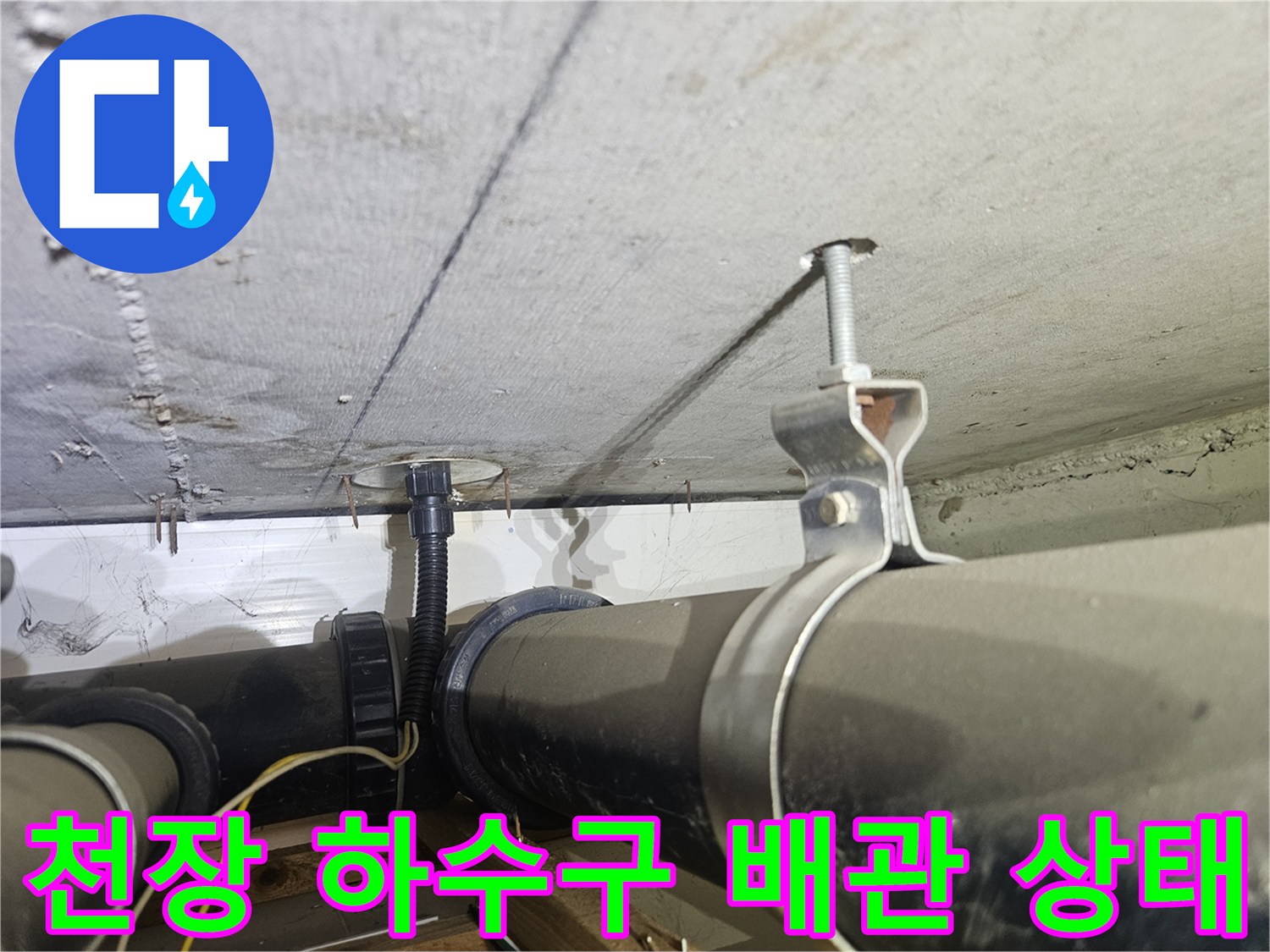천장에 설치된 검은색 관과 금속 나사산 고정 장치 상세 모습
