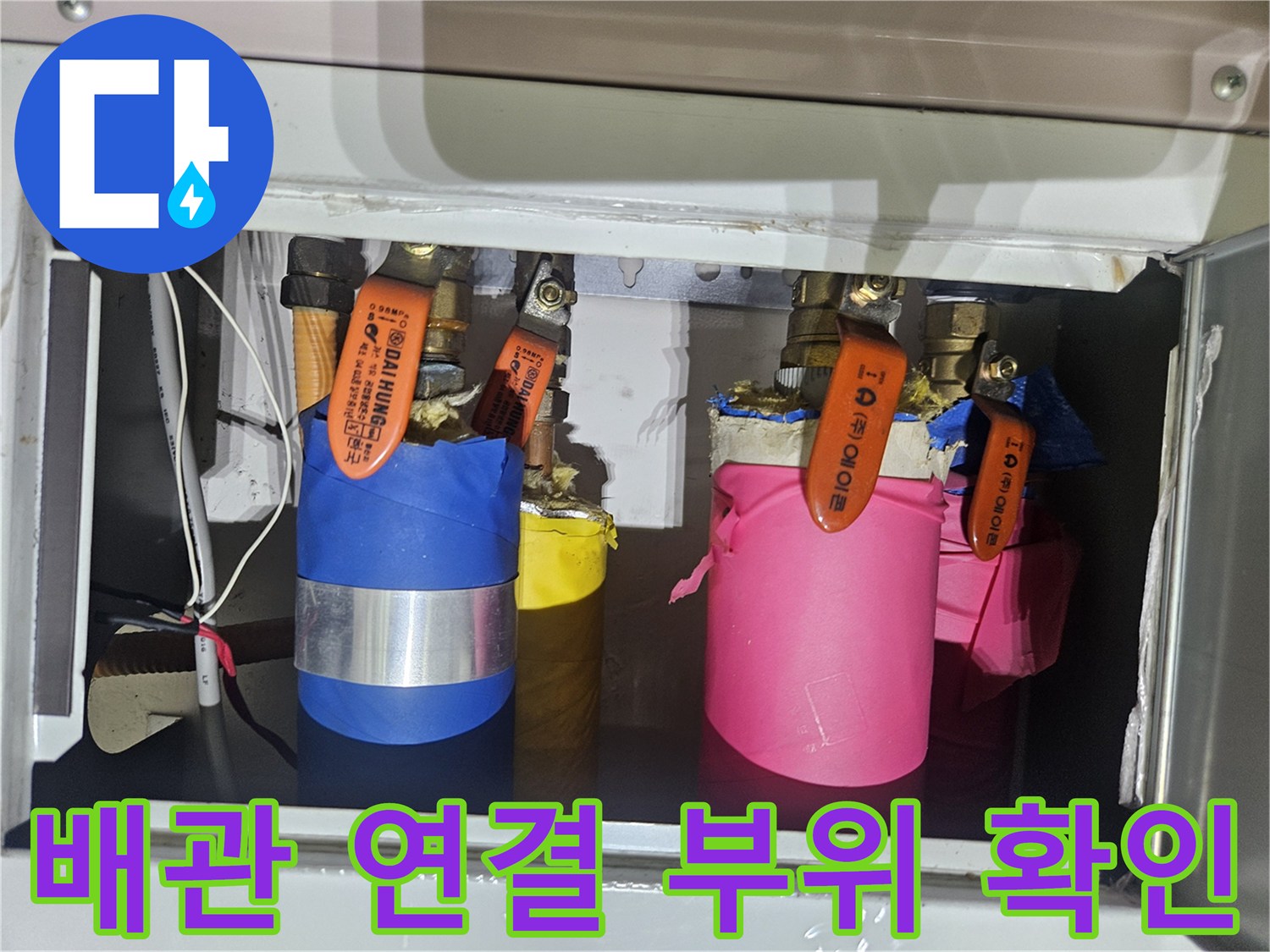 테이프로 마감된 배관과 주황색 밸브 장치의 상세 모습
