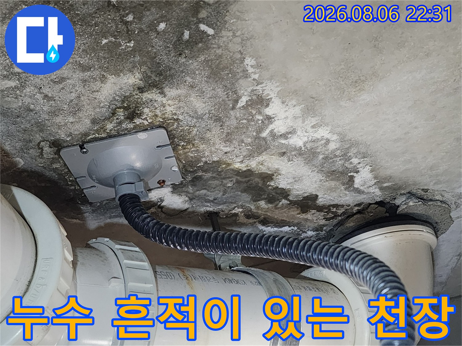 배관 주변의 콘크리트 오염과 습기를 보여주는 사진입니다.