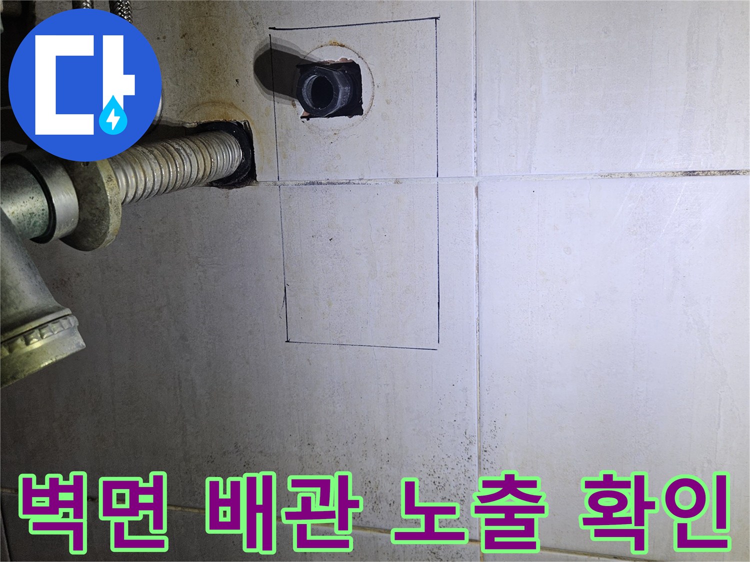 타일 제거 후 벽 안쪽의 수도 배관을 점검하는 장면입니다.
