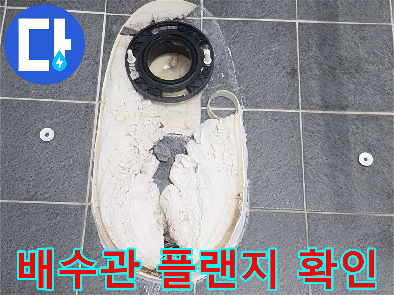 변기 배수구와 연결된 검은색 플랜지 부위의 모습입니다.