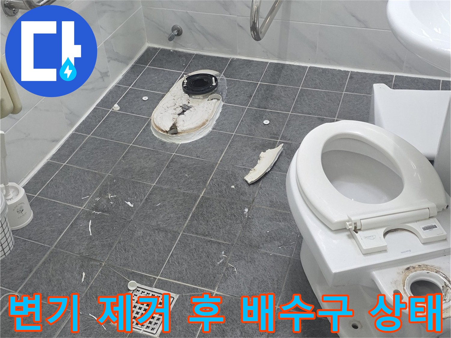 양변기를 탈거한 뒤 나타난 오염된 배수관과 바닥 타일의 모습입니다.