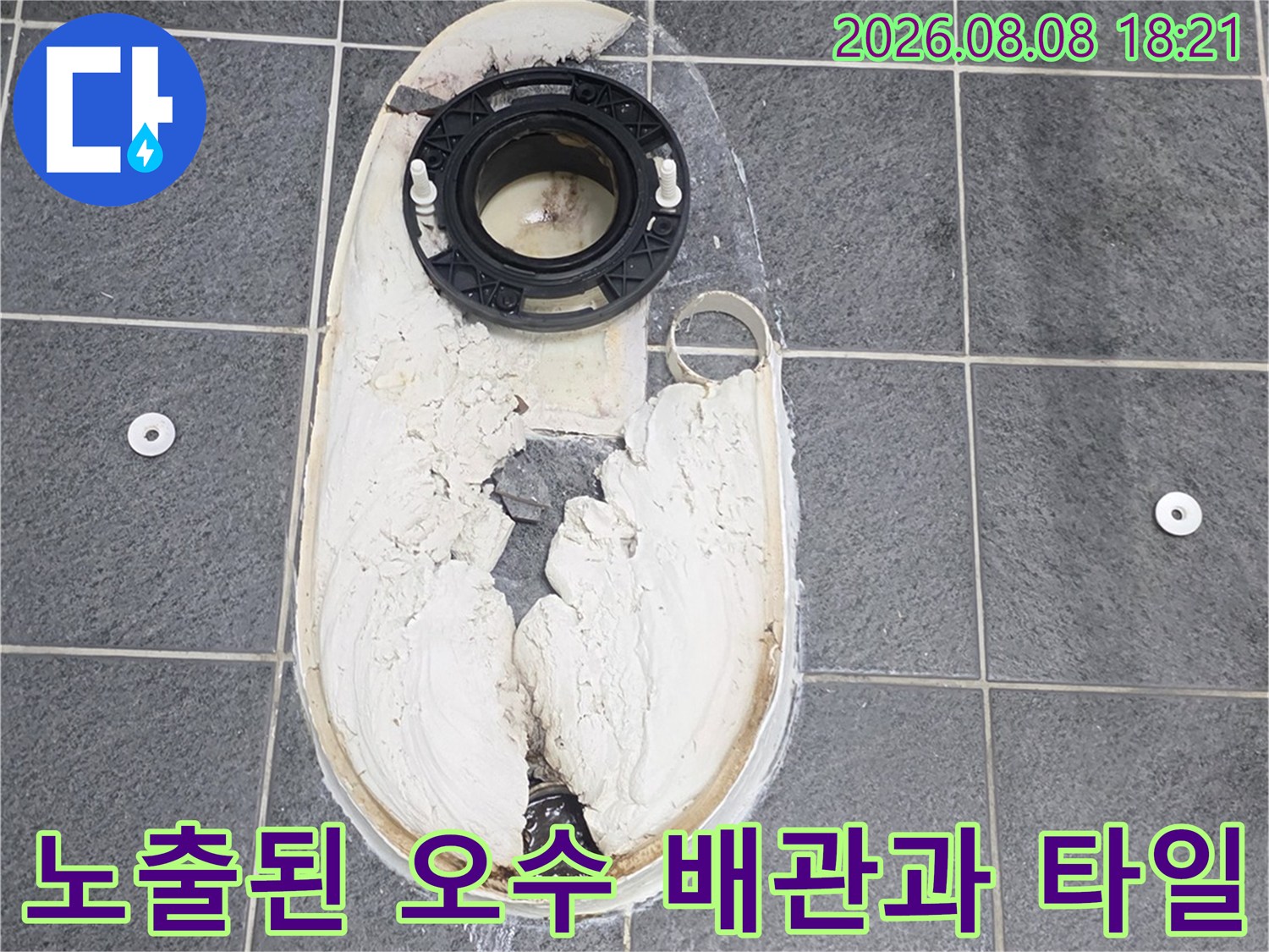 탈거된 변기 자리에 드러난 오수관과 주변 타일의 모습입니다.