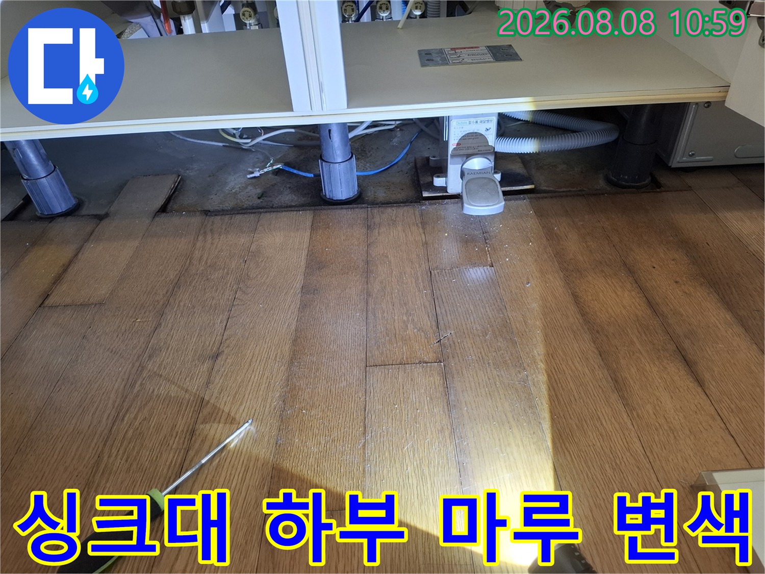 성동구 금호동 아파트-싱크대 아래쪽 마루가 젖어 변색된 상태를 점검 중입니다