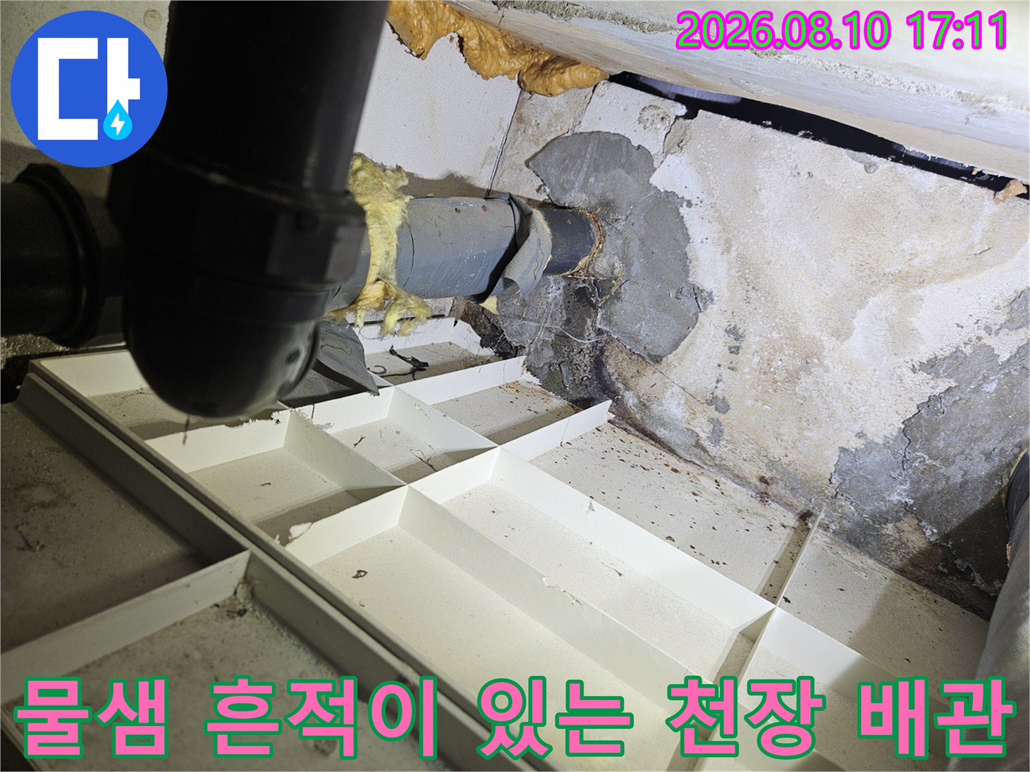 습기로 인해 얼룩이 생긴 천장 벽면과 하수 배관 모습입니다.