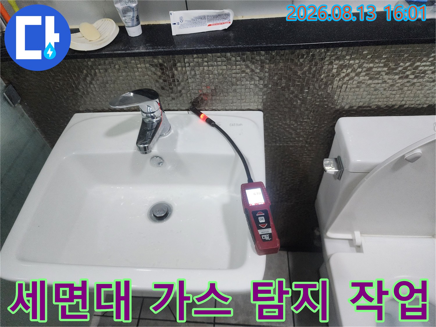 세면대 하단 배관에서 가스 탐지기를 활용하여 누수 지점을 찾는 모습입니다.