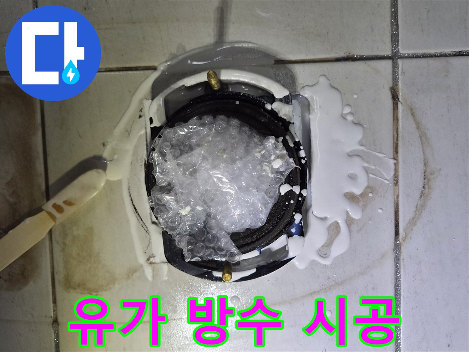 배수구 주변에 두껍게 발려진 흰색 방수재