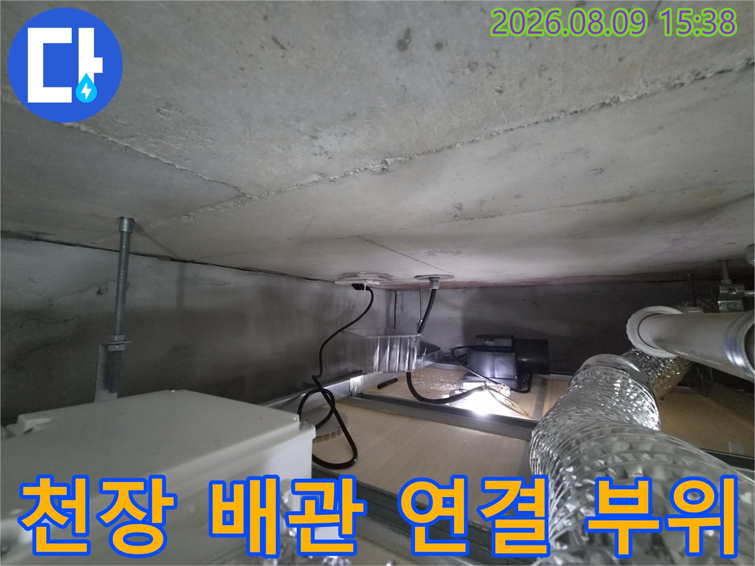 천장 구조물 내부에-노출된 배관과 콘크리트 슬래브입니다.