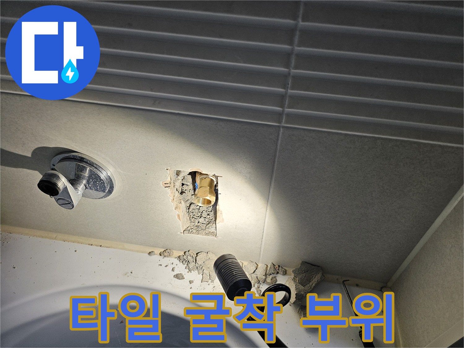 욕실 타일을 제거하여 드러난 배관 연결 지점의 모습