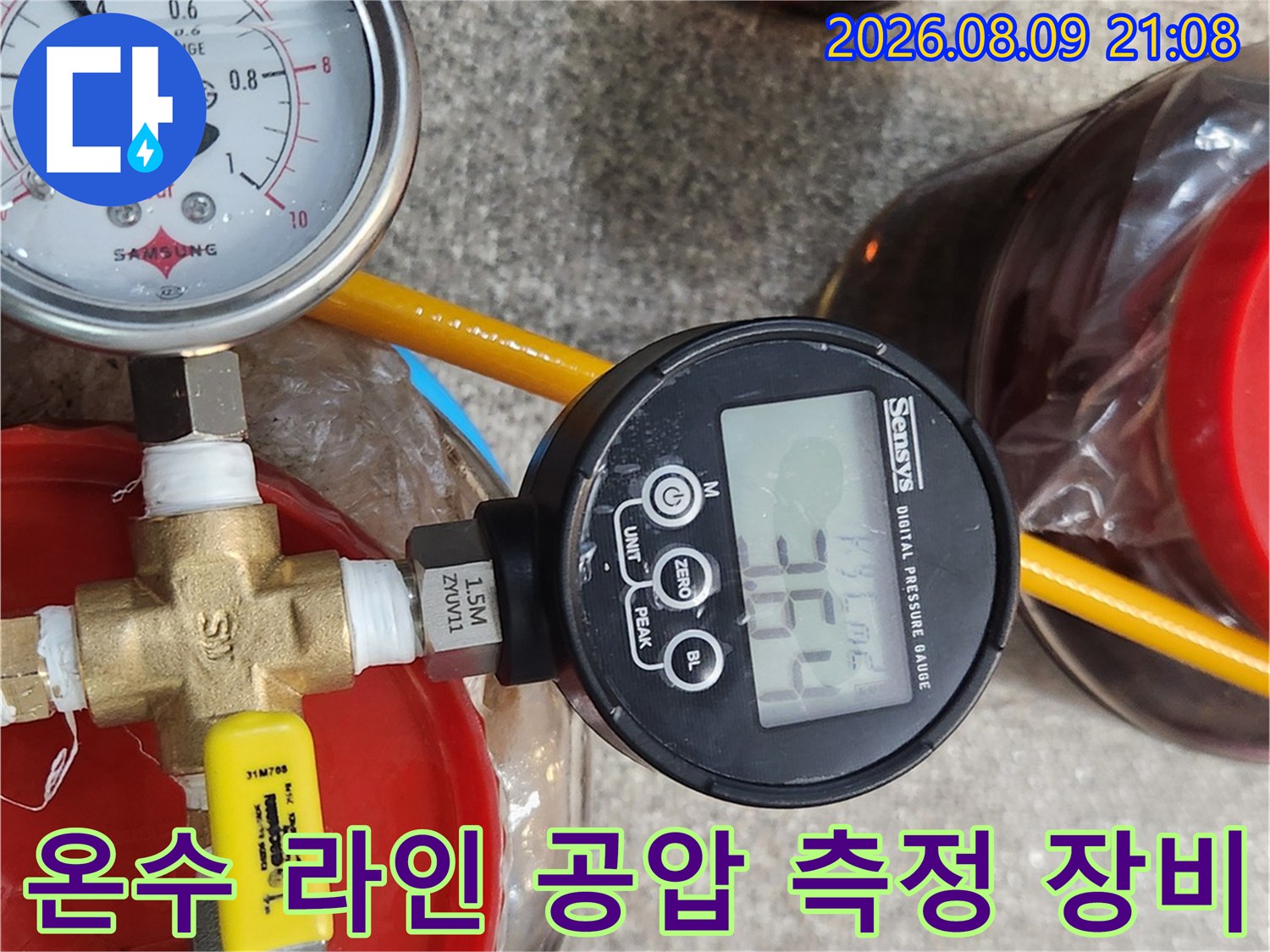 파란색 호스와 노란색 호스가 연결된 배관에 디지털-압력계가 설치된 모습