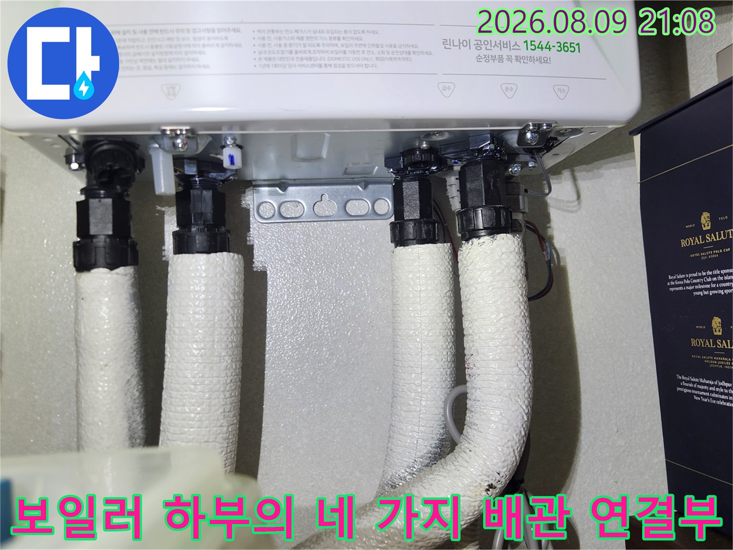흰색 보온재로 감싸진 4개의 보일러 배관이 본체 아래에 수직으로 설치된 상태