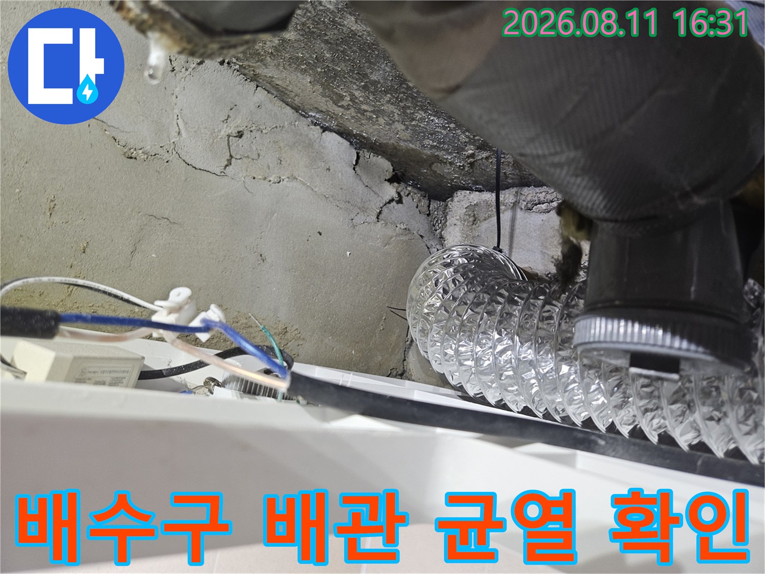 화장실 천장 안쪽의 은색 자재 배관과 노출된 콘크리트 틈새를 촬영한 이미지입니다.