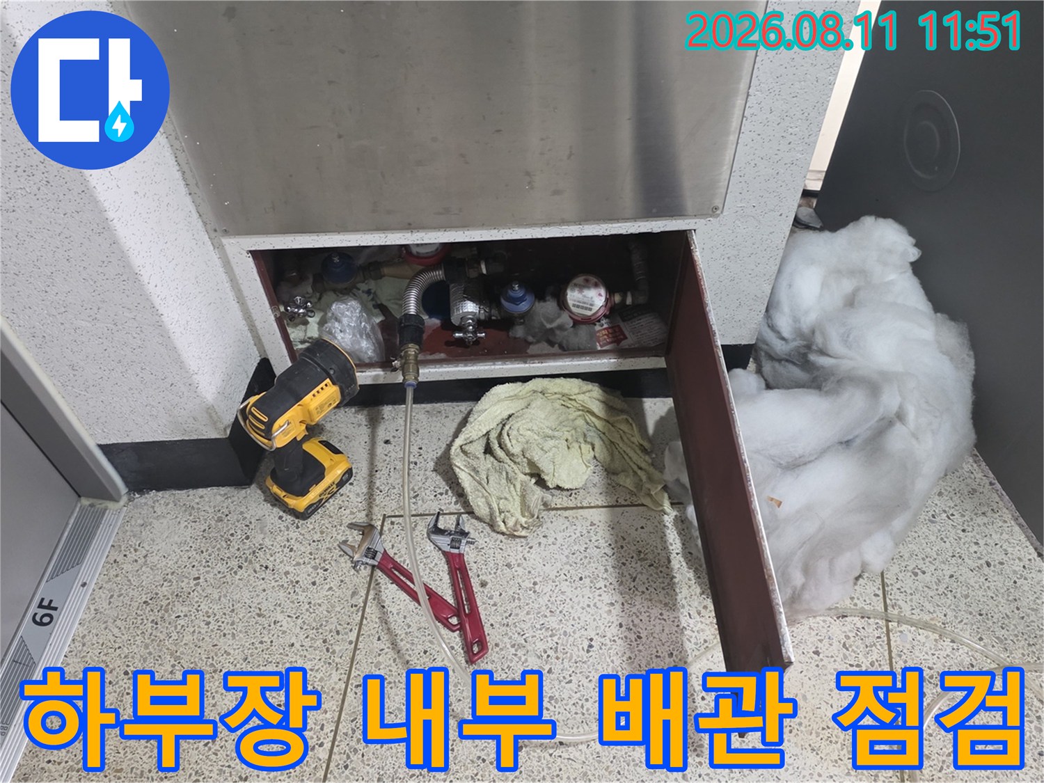 아파트 하부장 아래쪽 배관 부위를 점검하기 위해 열어둔 작업 현장 모습