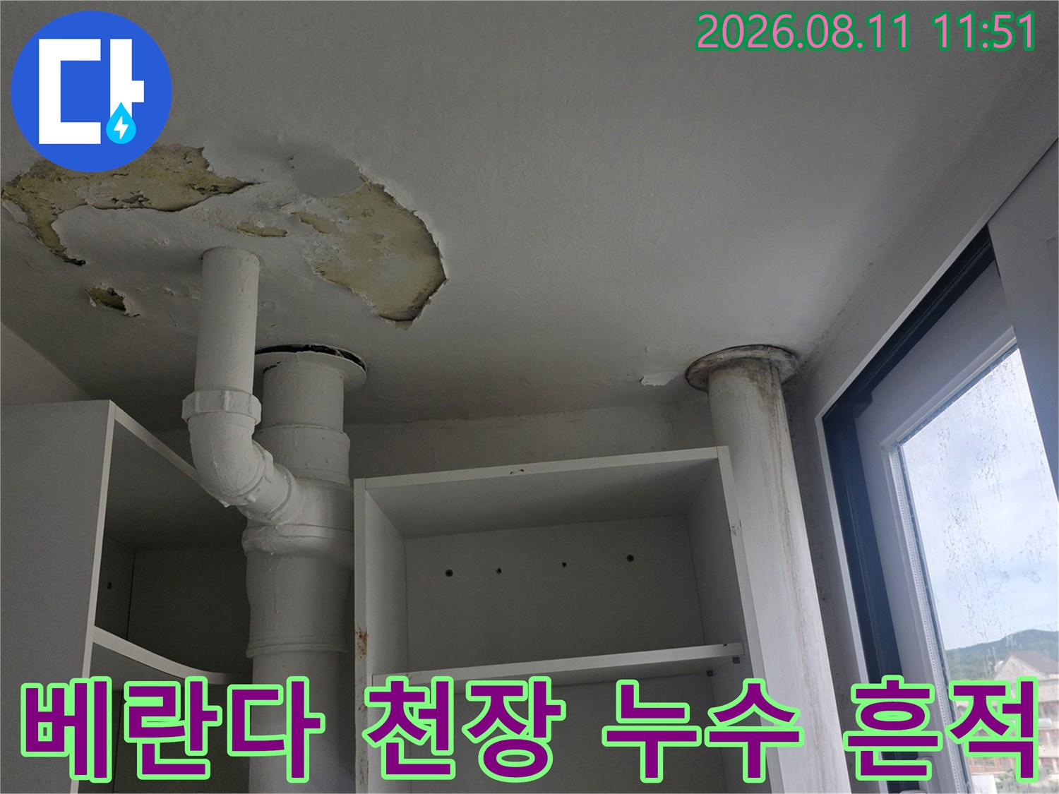 하얀색 배관 아래쪽 천장이 벗겨지고 얼룩진 모습의 사진입니다.