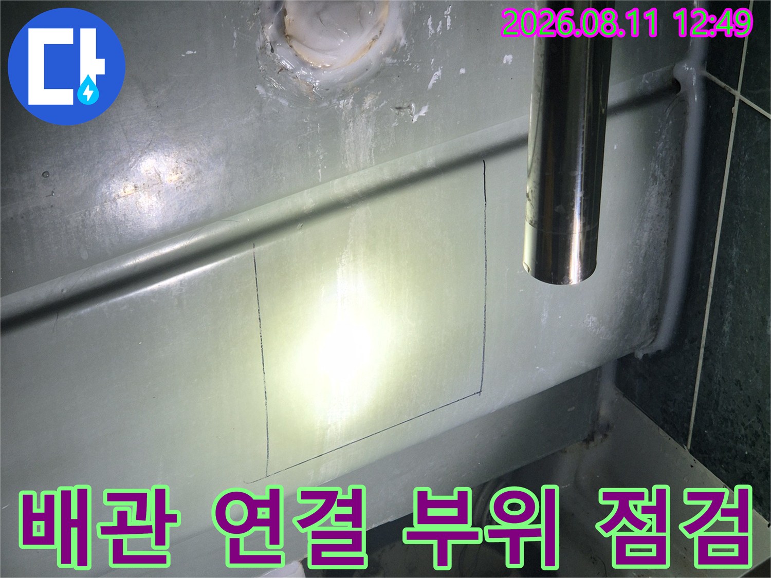 절개된 욕조 패널 사이로 배관 주변을 세밀하게 조사합니다.
