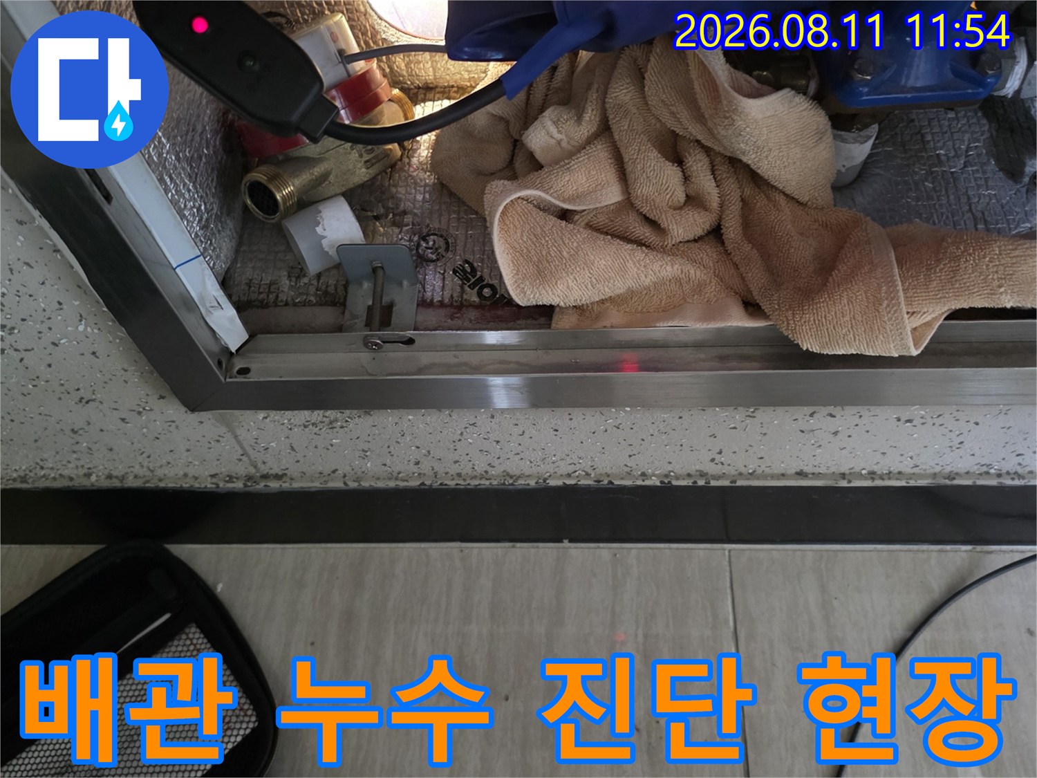계량기함 내부에 설치된 배관의 결함 부위를 찾기 위해 장비를 운용하는 장면입니다.