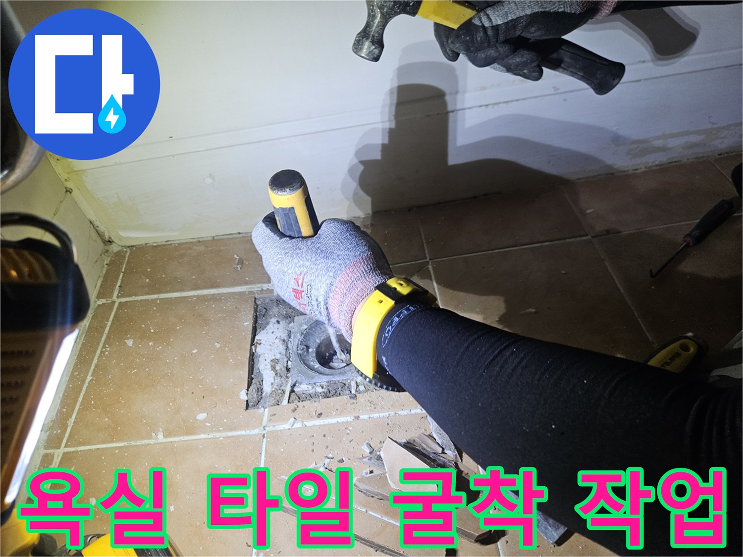 망치와 장비를 이용해 배수구 주변 타일을 깨는 과정