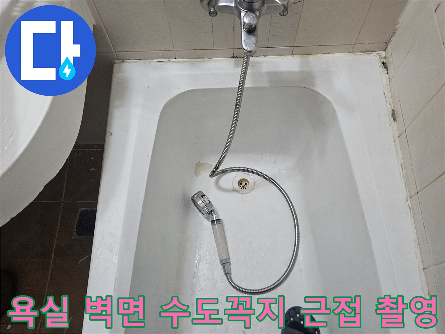 벽면에 고정된 수전과 연결된 샤워 호스 이미지