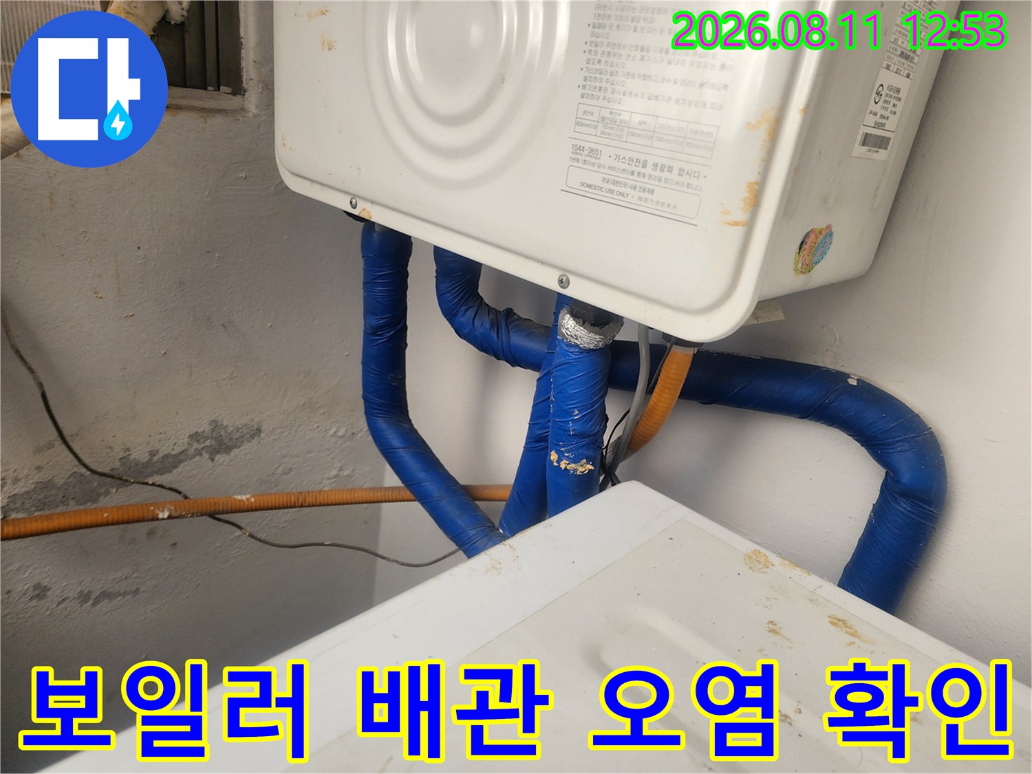 파란색 보온재로 감싸진-보일러 하단부 배관의 근접 촬영