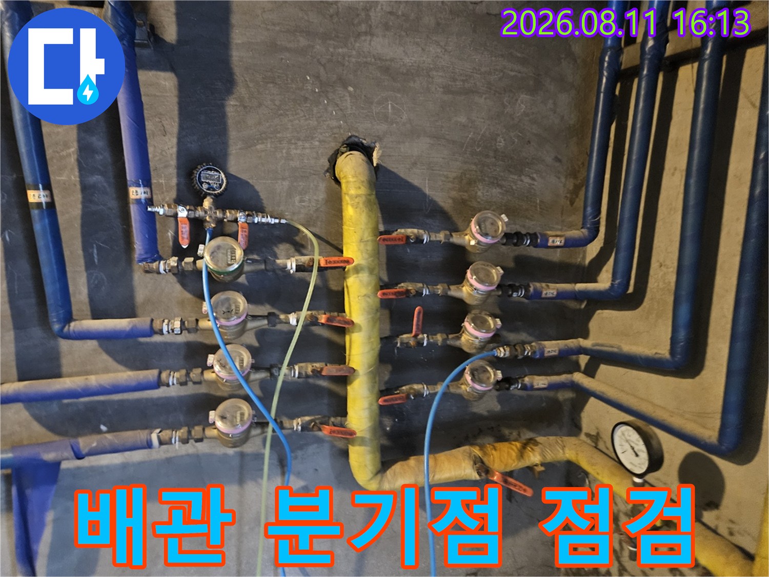 노란색 메인 배관과 파란색 가지 배관이 연결된 계량기 부위