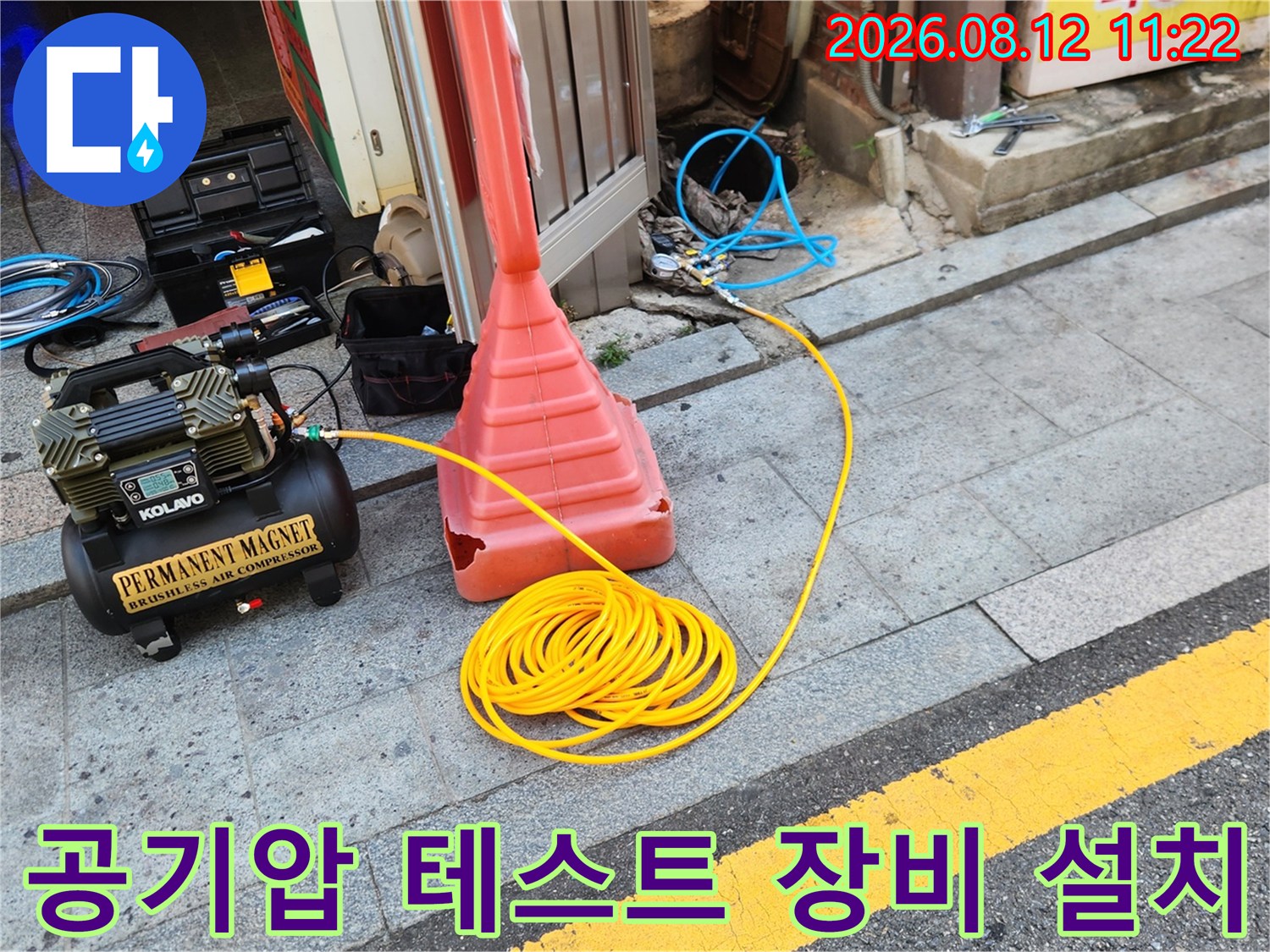 배관 누수를 찾기 위해 현장에 세팅된 공기 압축기와 노란색 호스