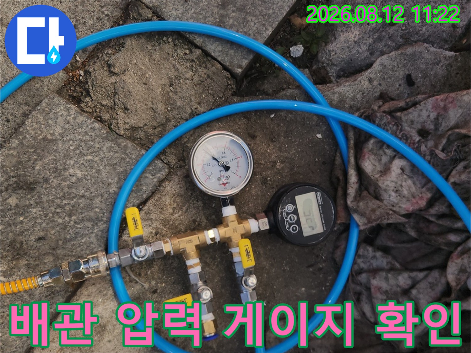 파란색 호스가 연결된-배관용 압력 측정 장비 모습