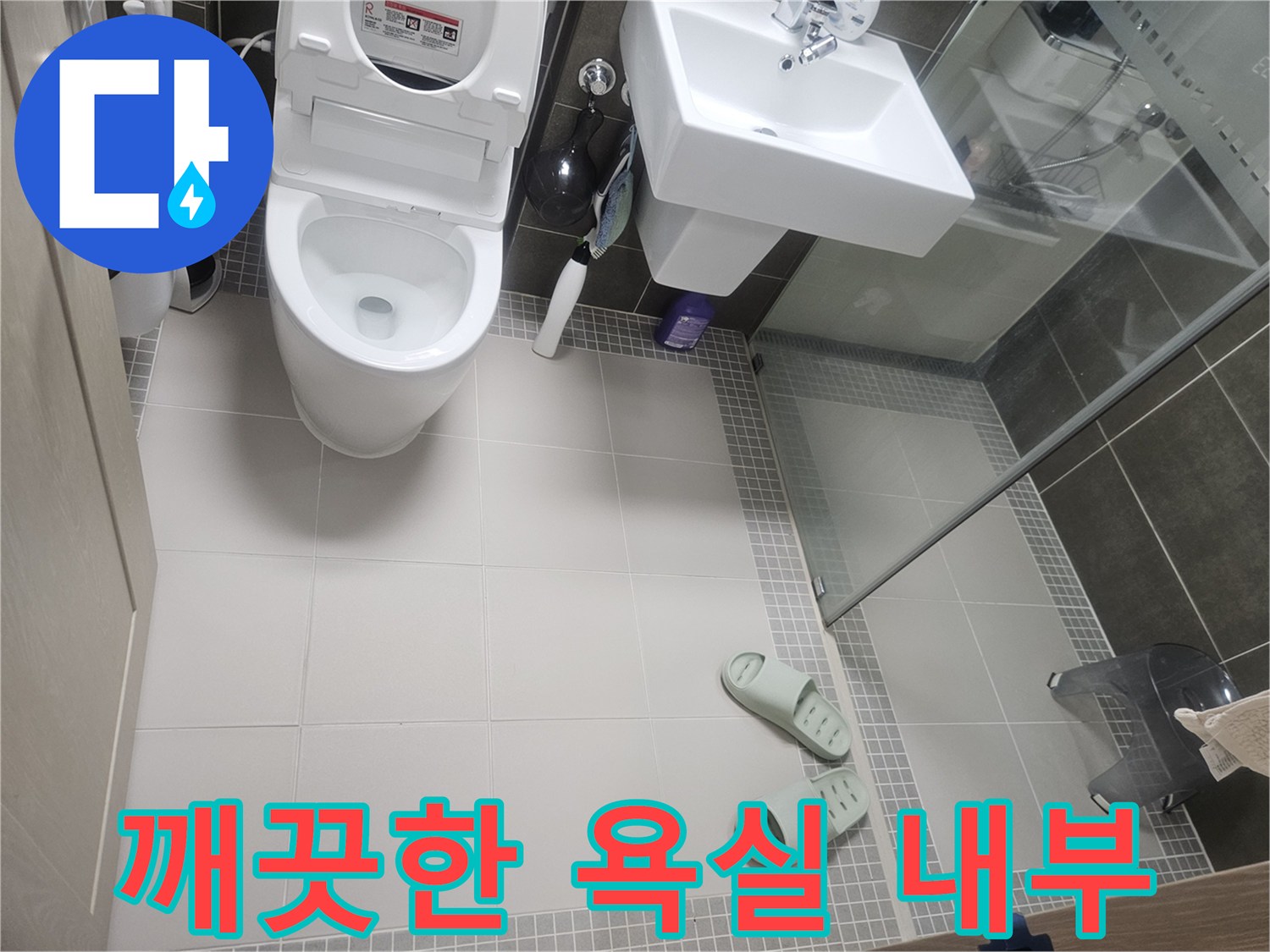 변기와 세면대 주변의 타일 바닥 상태를 촬영한 사진