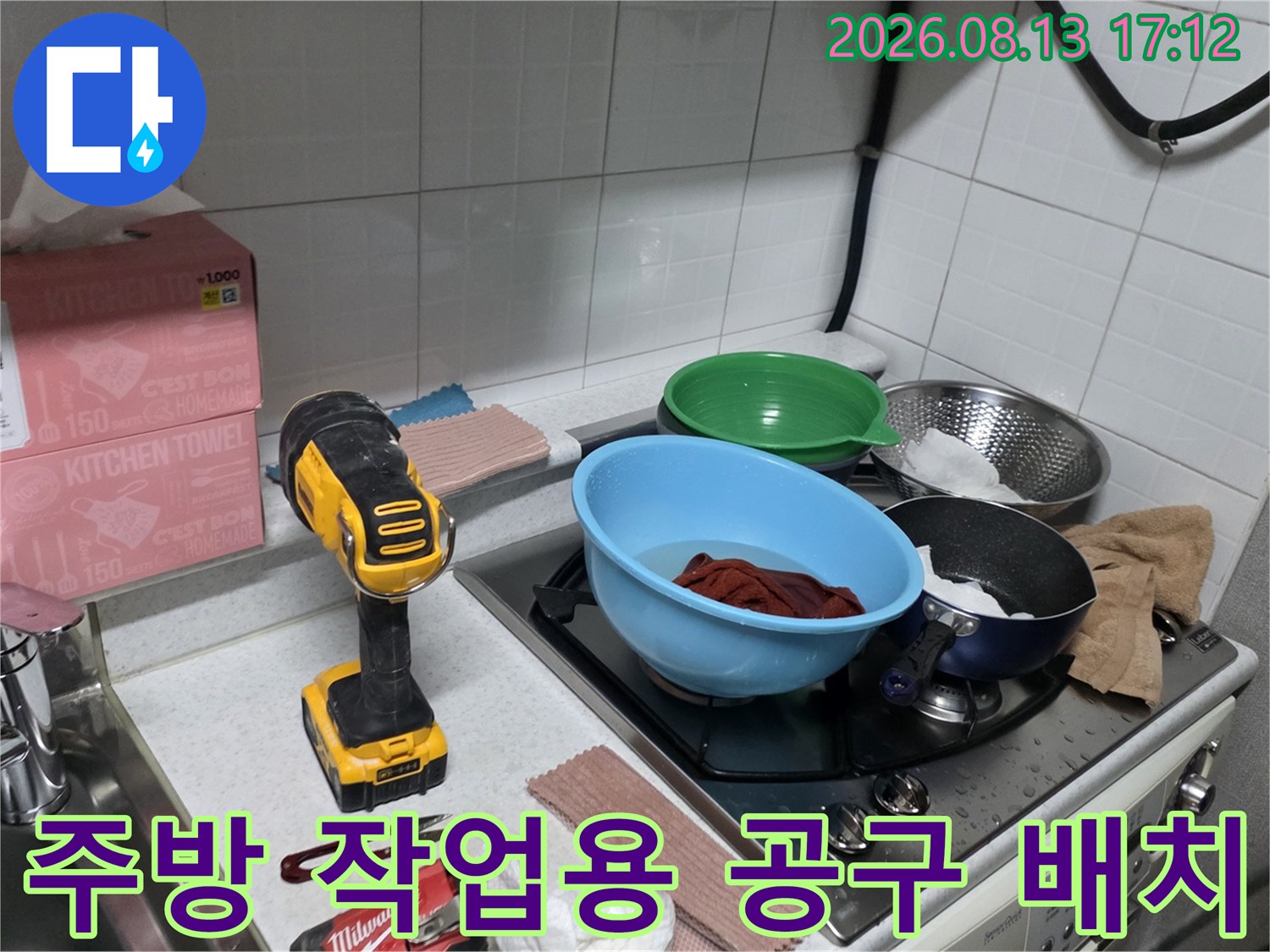 싱크대 옆 조리대에 놓인 전동 드릴과 키친타월 및 식기류