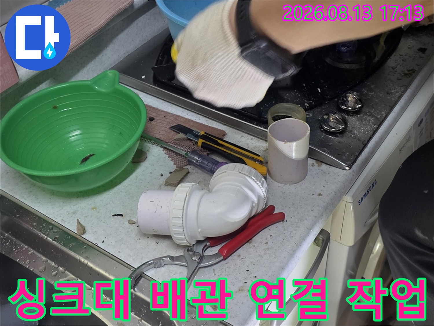 싱크대 하단 배관의 누수를 잡기 위해 부품을 재조립하는 장면