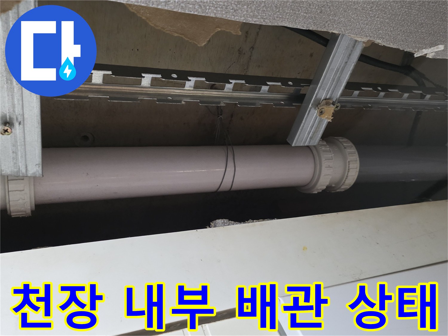 천장 구조물 내부에 설치된 하얀색 배관과 금속 지지대 프레임
