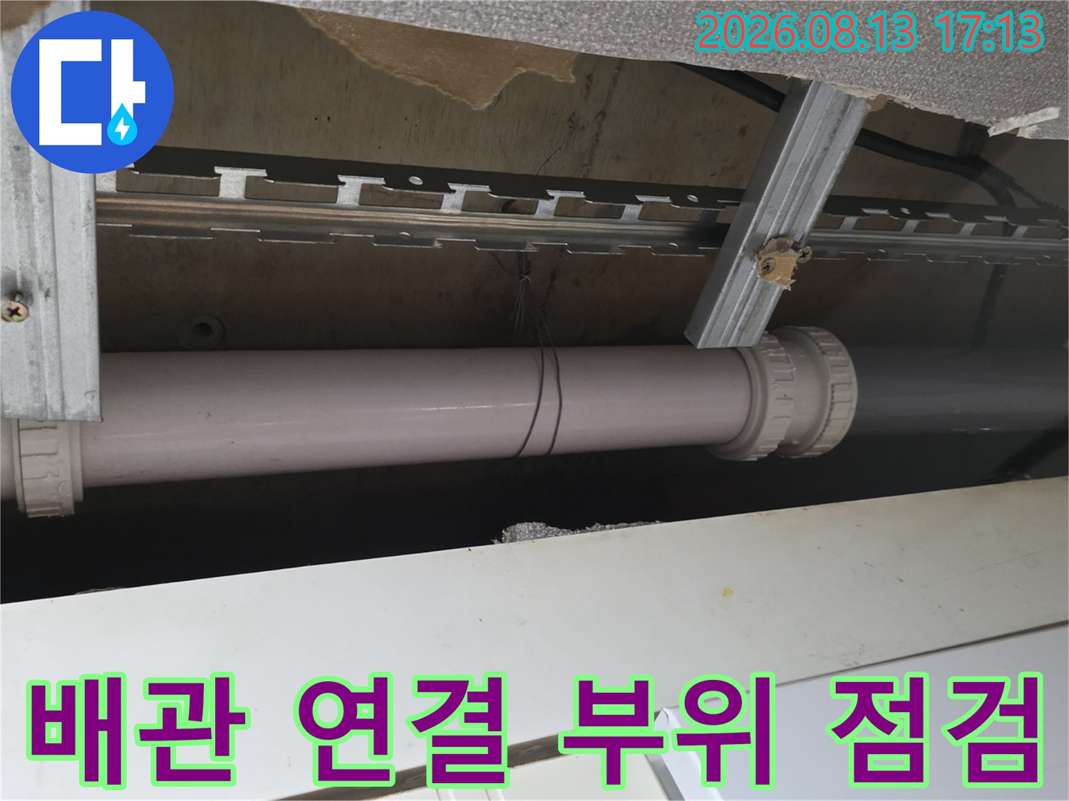 천장 내부의-PVC 배관과 지지 구조물을 근접 촬영한 사진입니다.