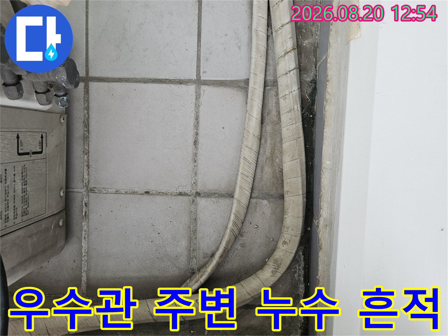 우수관 배관 주변 타일의 변색과 습기 상태를 촬영했습니다.