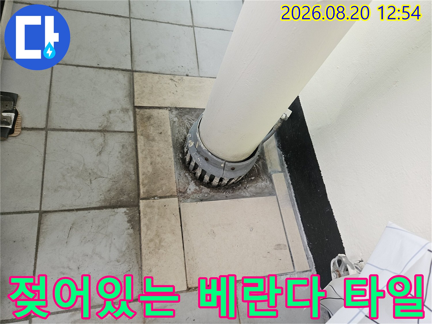 우수관 배관 주변의 젖은 타일과 오염된 줄눈 부위