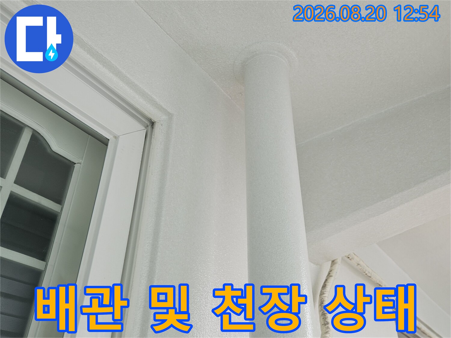 하얀색 우수관 배관과 인접한 창호 프레임의 연결 부위 사진입니다