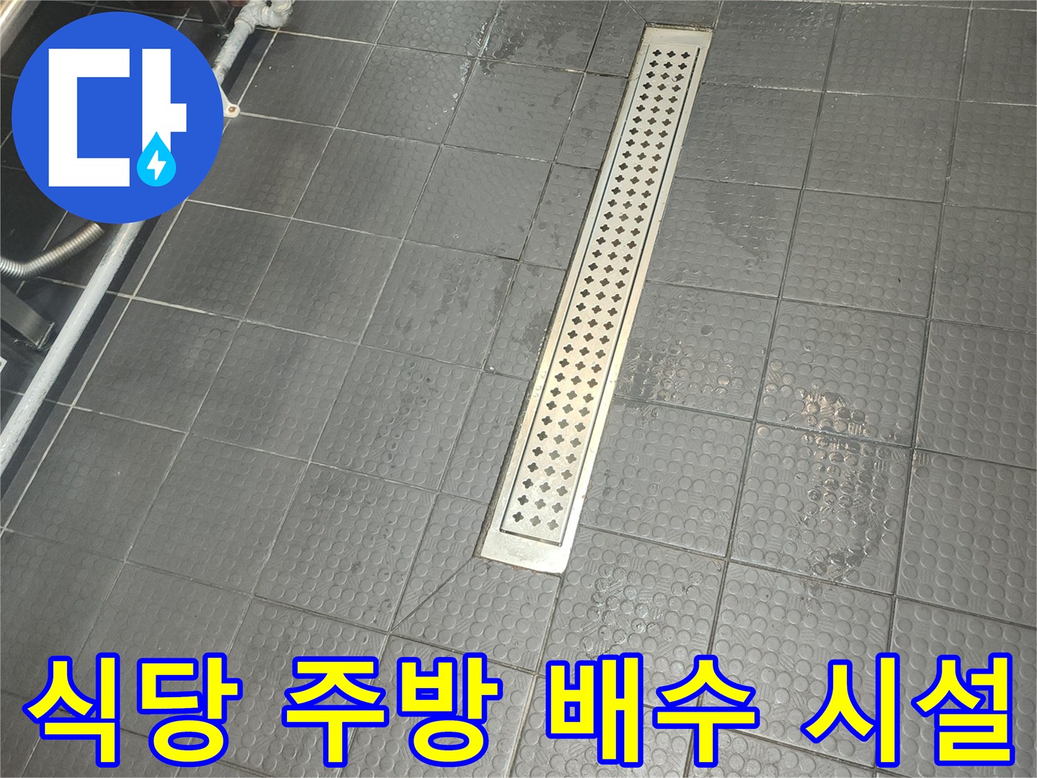 어두운 색상의 타일 바닥과 스테인리스 배수구가 설치된 식당 내부