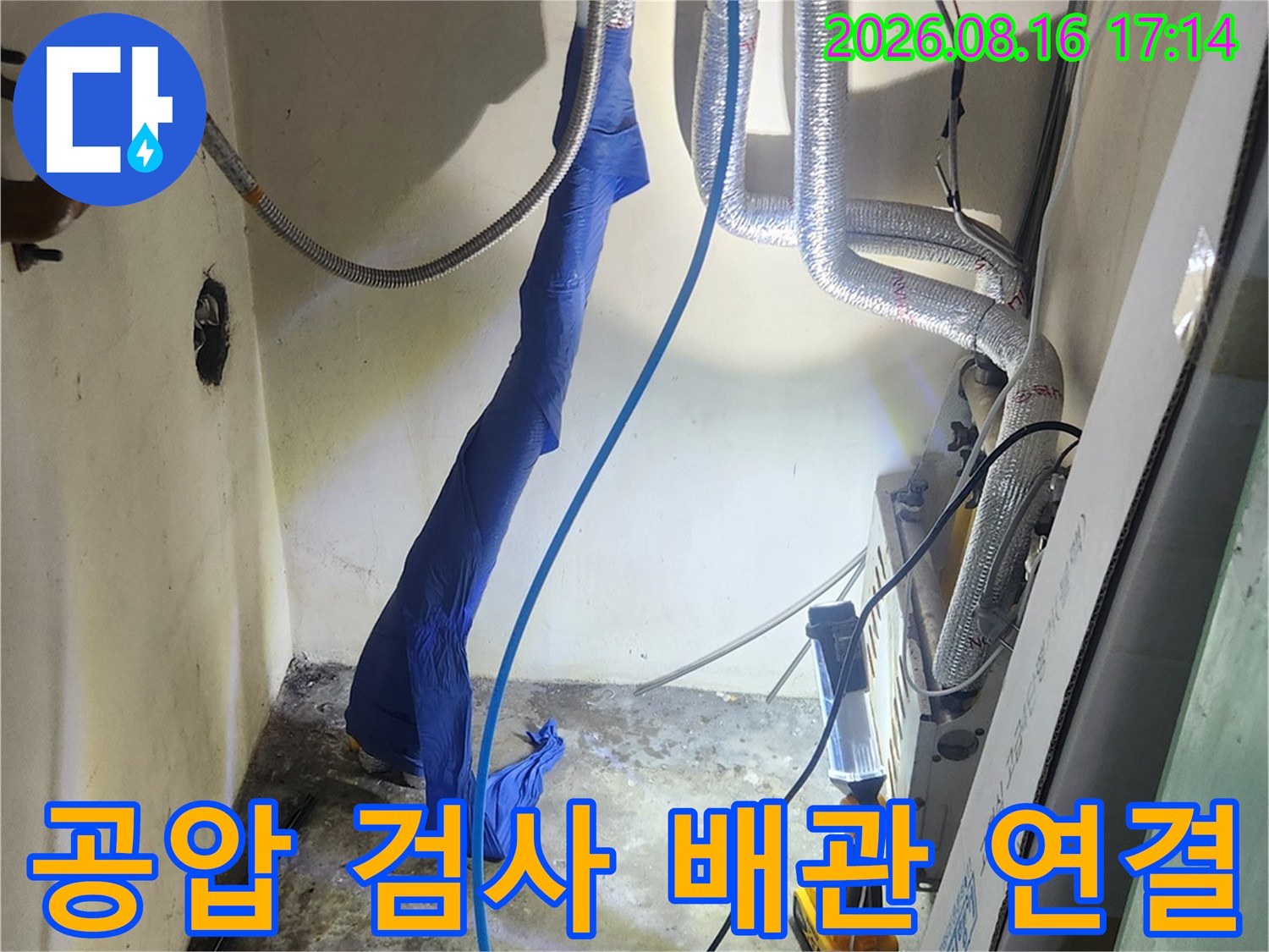 보일러 하단 배관에 연결된 파란색 호스와 압력계 장치
