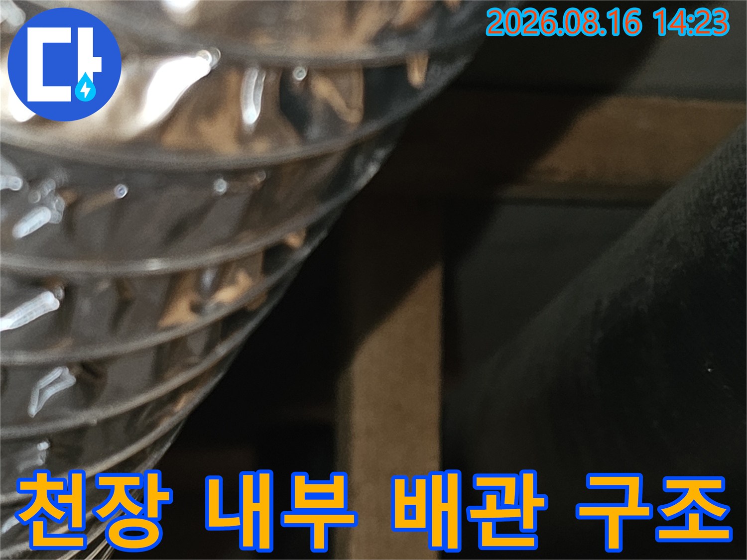 은박 소재의 자재와 검정색 배관이 연결된 천장 내부