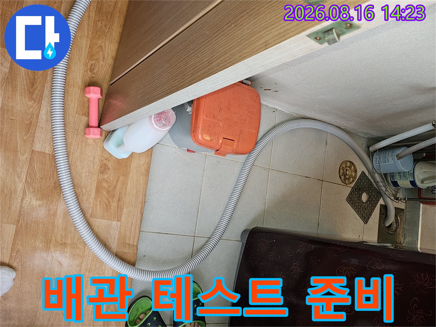 화장실 문 근처에서 진행 중인 배관 압력 점검 장비 설치 모습