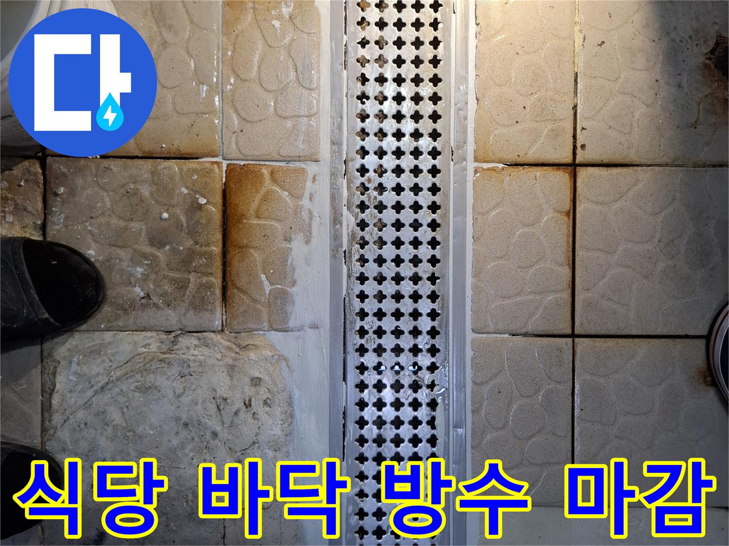 배수 트렌치 주변의 벌어진 타일 틈새를 방수재로 채워 넣는 과정입니다.